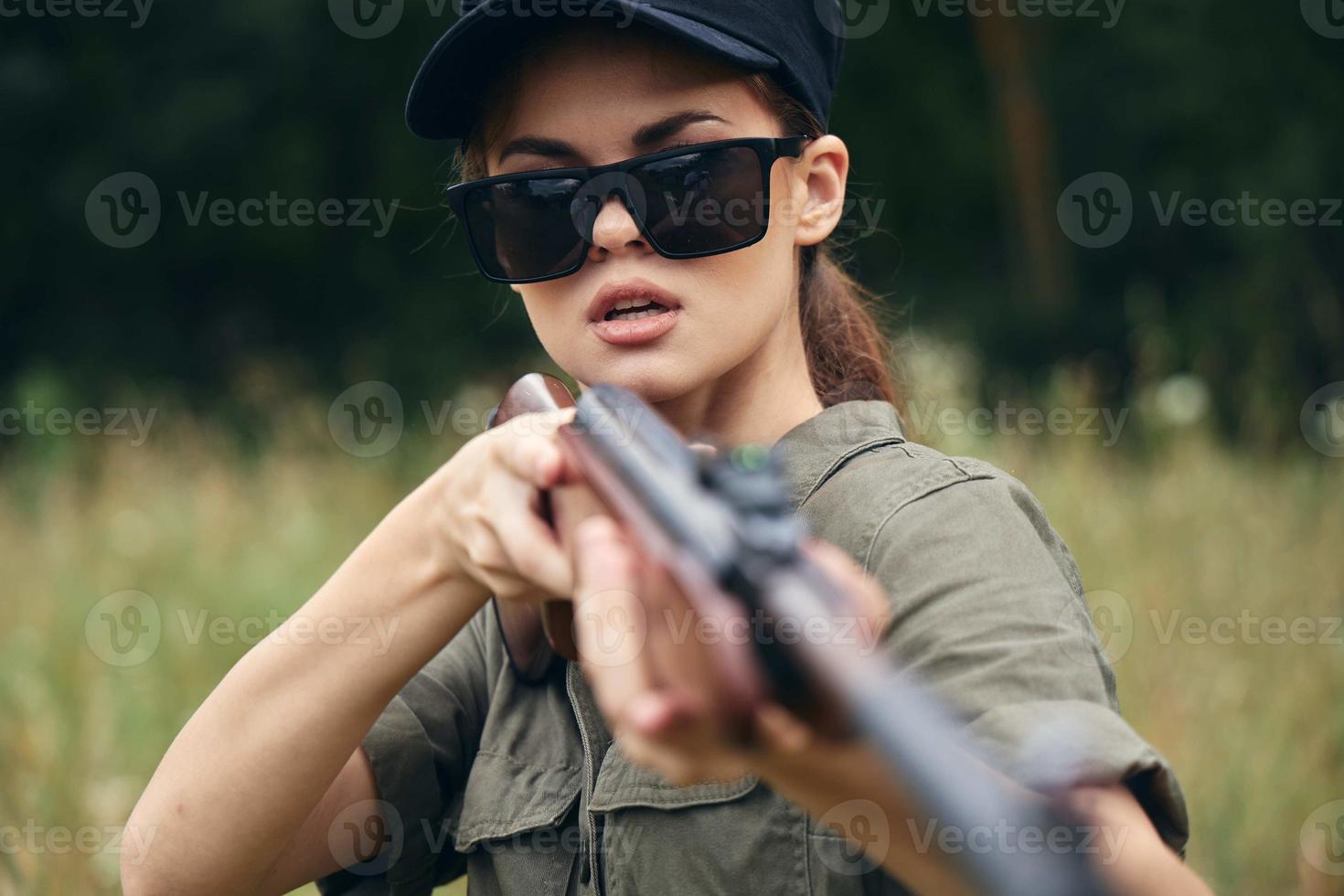 femme sur Extérieur dans des lunettes de soleil armes dans main Frais air photo