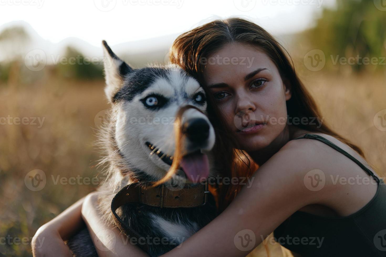 femme séance dans une champ avec une teckel chien souriant tandis que dépenses temps dans la nature avec une ami chien dans l'automne à le coucher du soleil photo