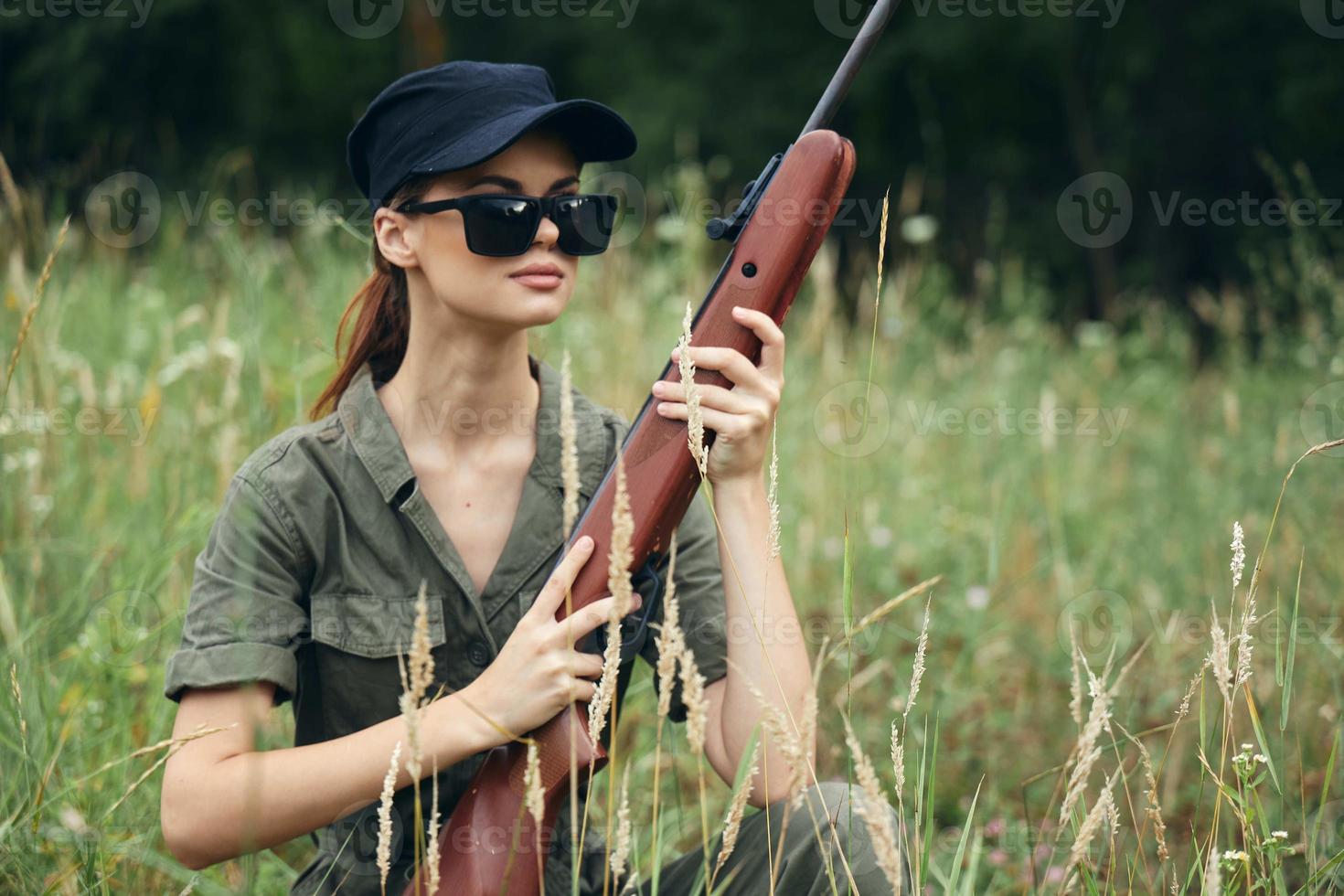 femme des lunettes de soleil avec armes dans main chasse mode de vie noir casquette vert photo