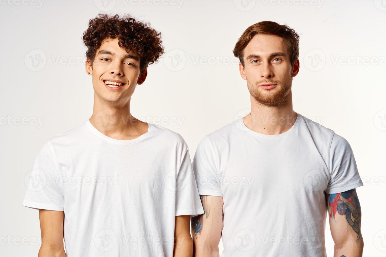 deux de bonne humeur copains dans blanc t-shirts émotions studio photo