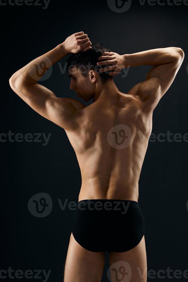 Masculin athlète posant sur foncé Contexte retour vue photo