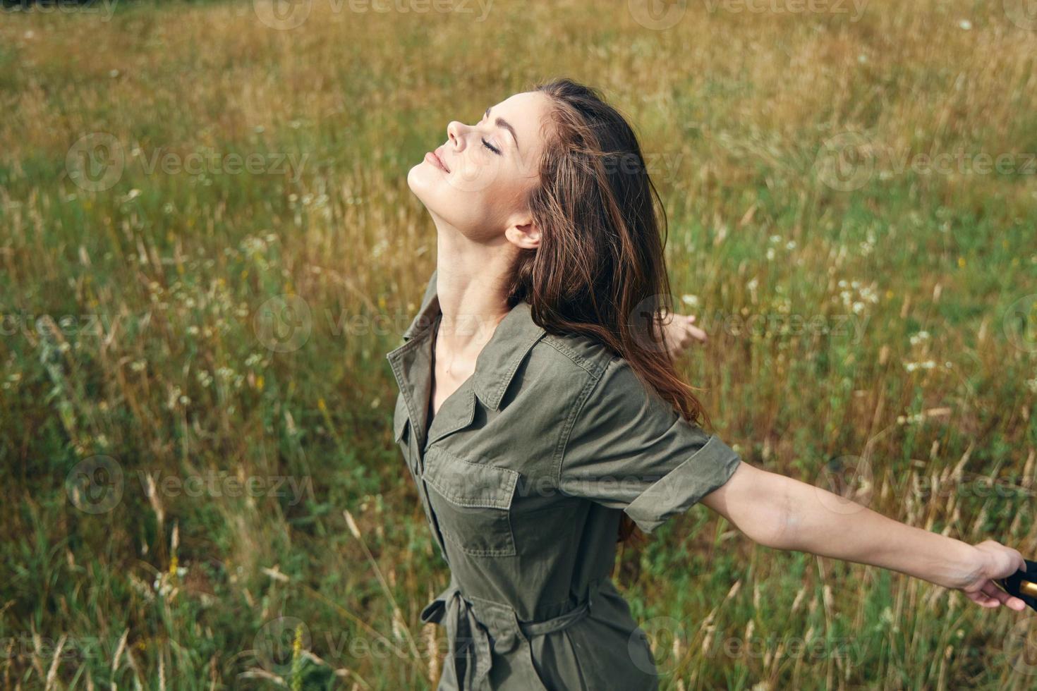 femme dans vert combinaison avec fermé yeux profiter liberté photo