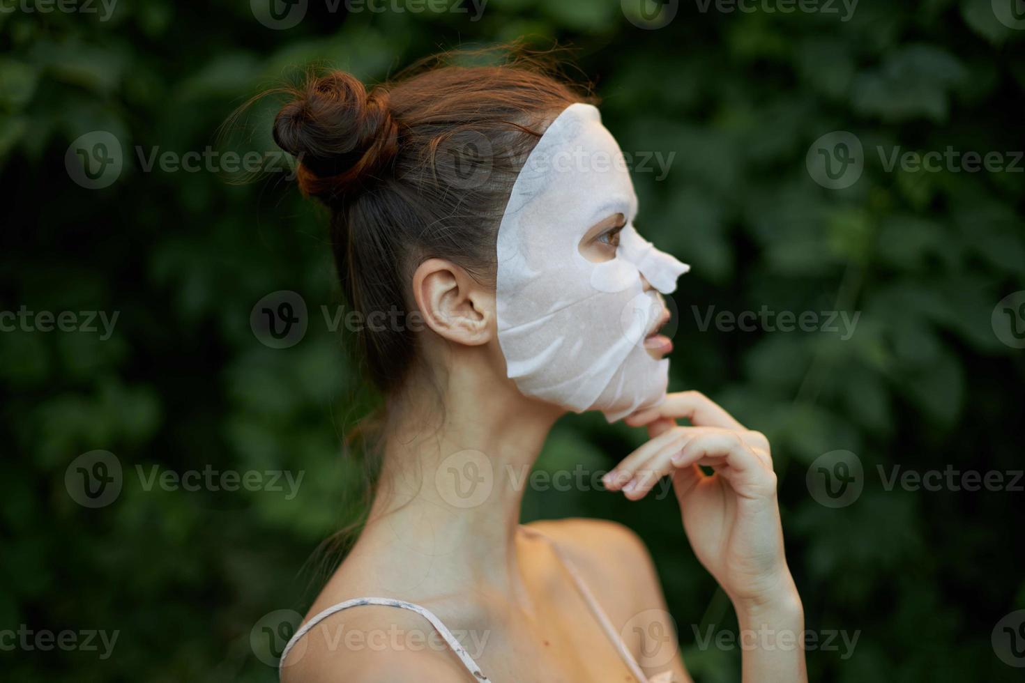 portrait de une femme anti-rides masque peau se soucier vert feuilles dans le Contexte photo