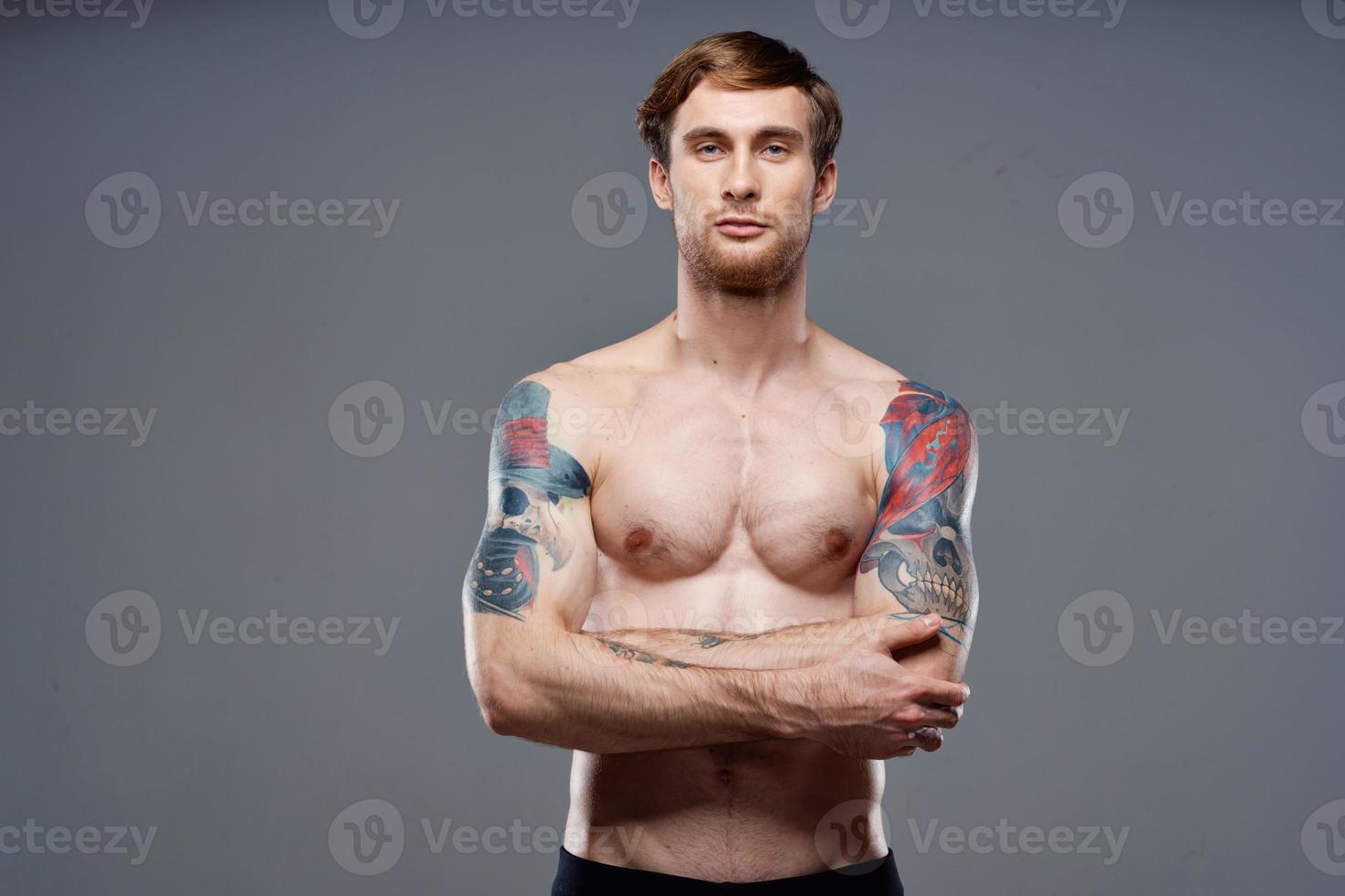 homme avec tatouages sur le sien bras pompé en haut torse faire des exercices tondu vue bodybuilder photo