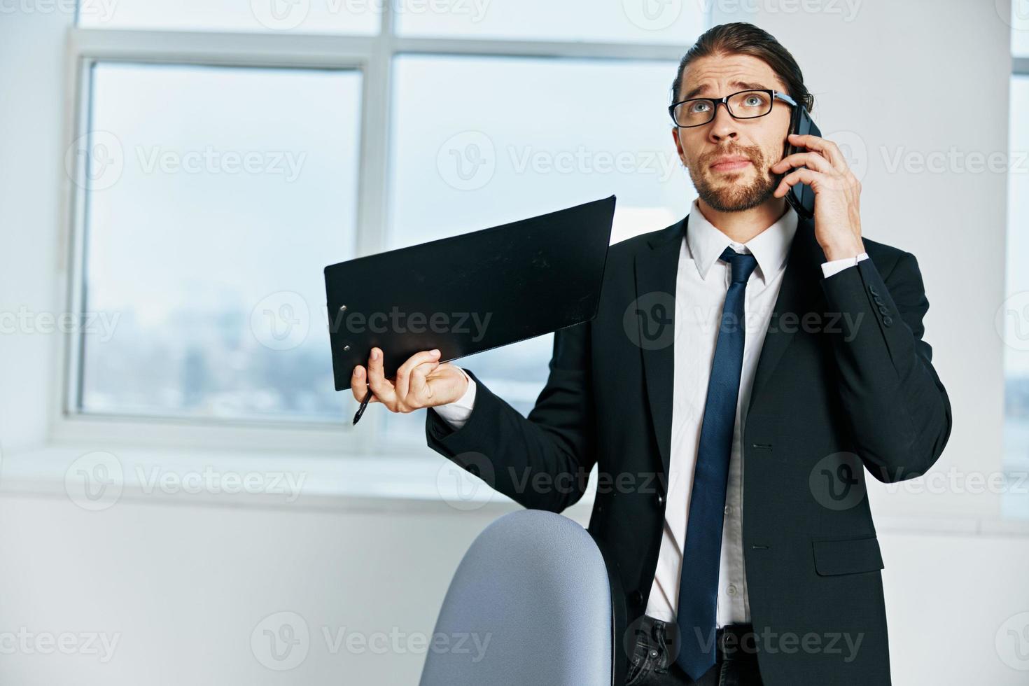 homme dans une costume les documents dans main la communication par téléphone exécutif photo