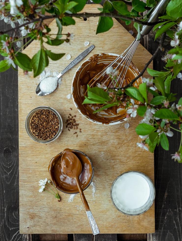 Faire du café dalgona coréen à la mode à l'extérieur avec tous les ingrédients sur une planche de bois à l'extérieur par une journée ensoleillée photo