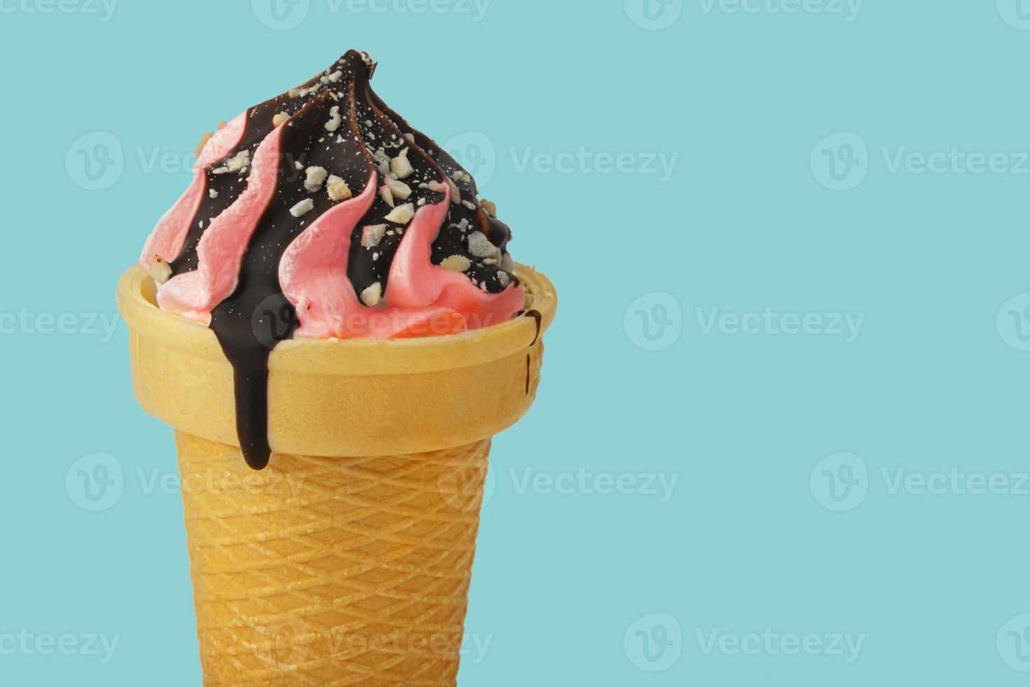 la glace crème. sucré rose la glace crème dans une gaufre cône versé avec Chocolat sur une turquoise background.beautiful dessert. photo