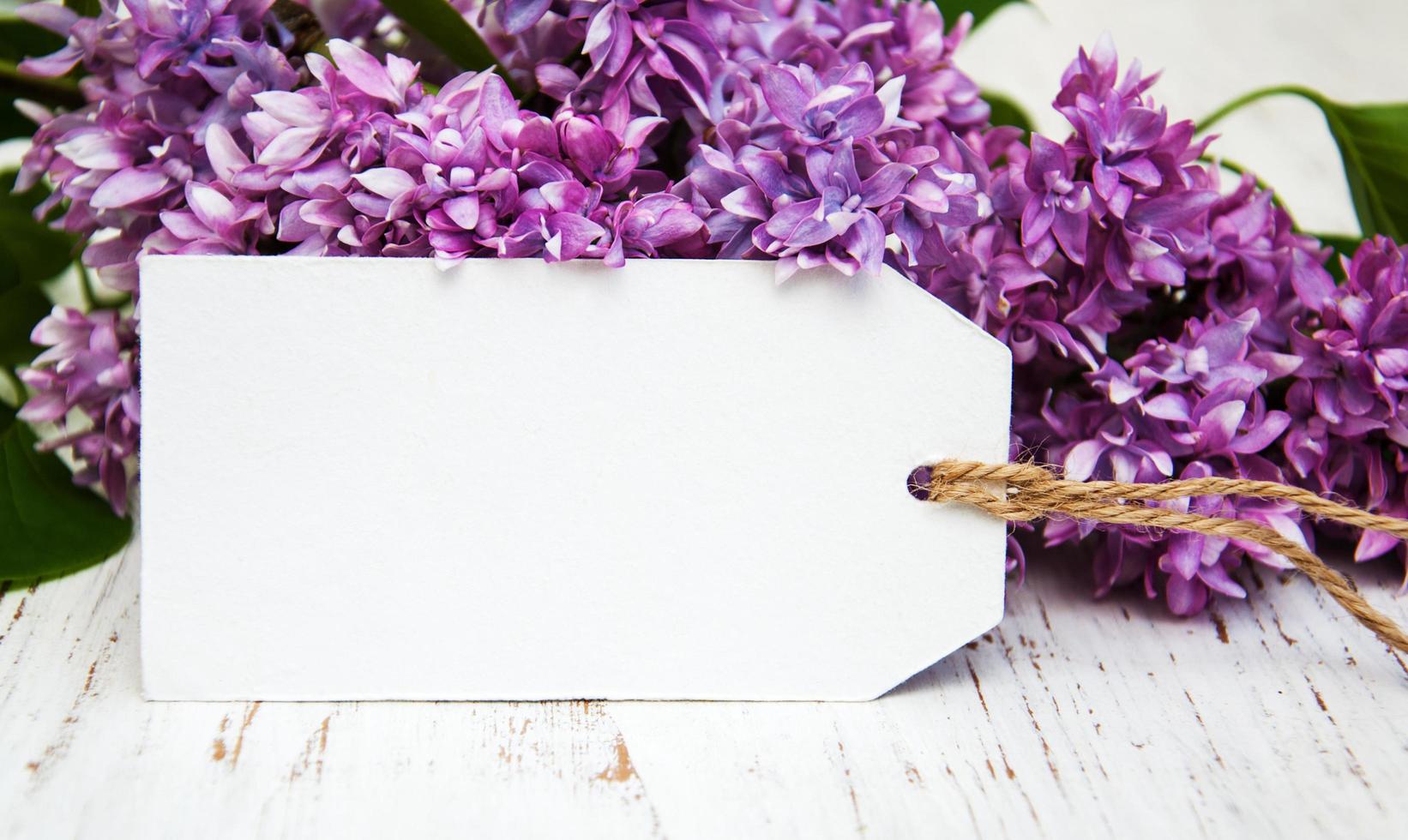 Fleurs lilas avec une balise vide sur un vieux fond en bois photo