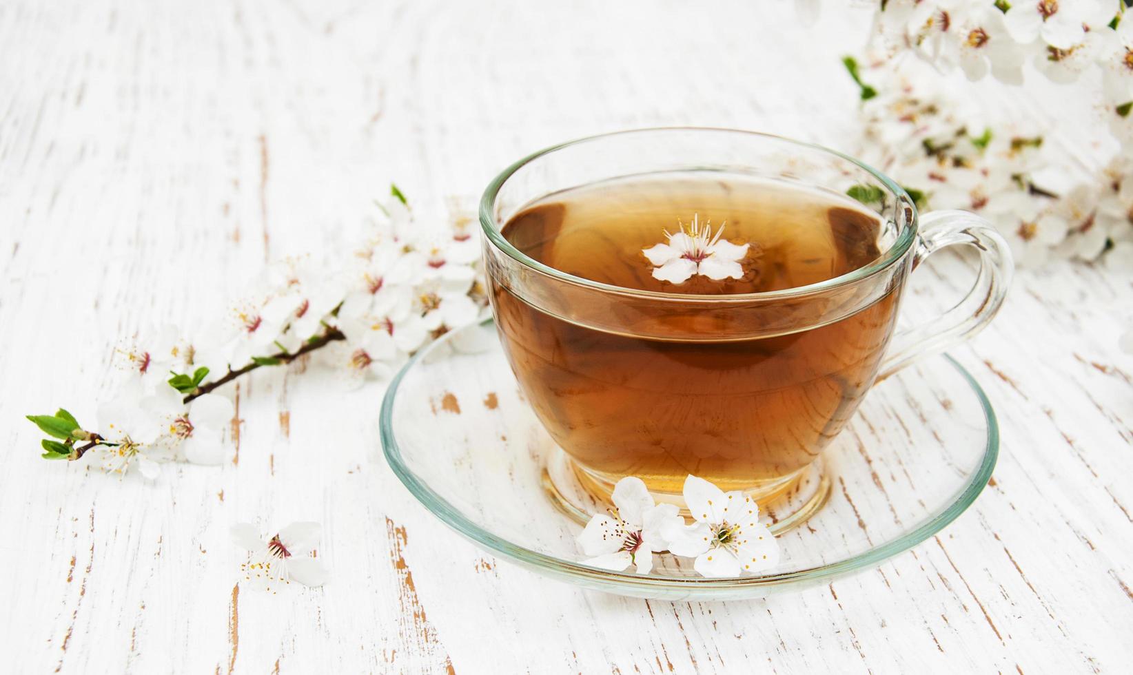 Tasse de thé et fleurs d'abricot de printemps sur un fond en bois photo