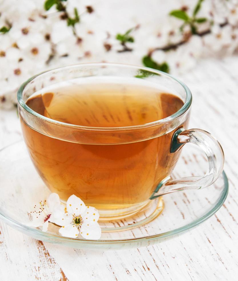 Tasse de thé et fleurs d'abricot de printemps sur un fond en bois photo