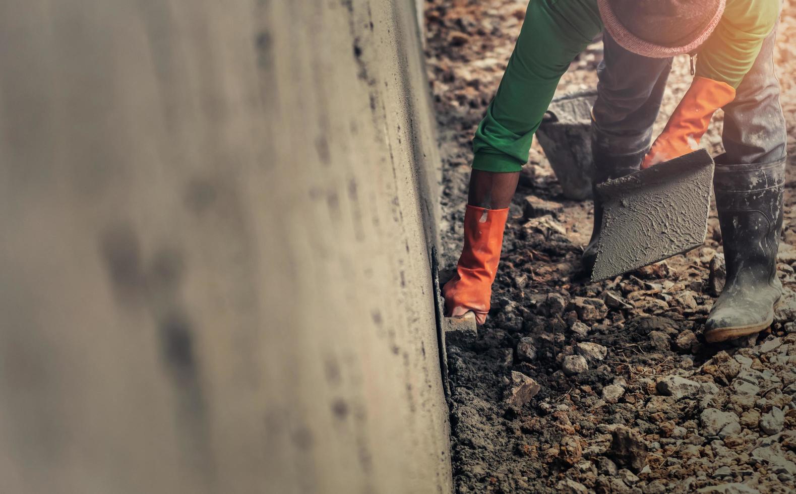 fermer main ouvrier plâtrage ciment sur mur pour bâtiment maison photo