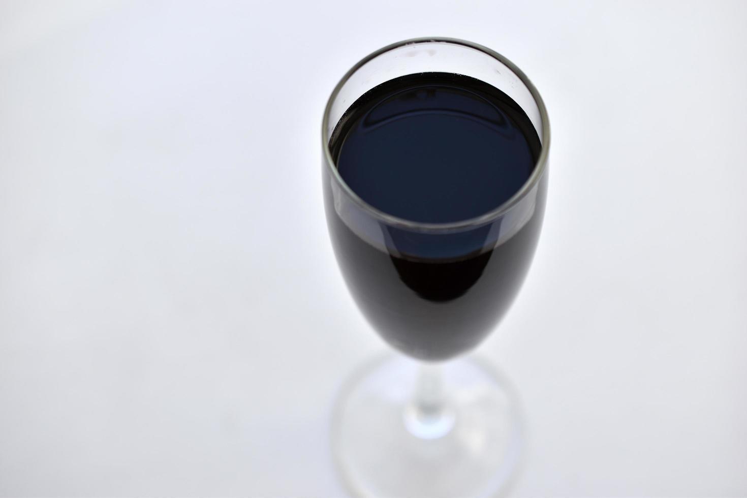 petit verre de vin rouge sur fond blanc avec des ombres photo