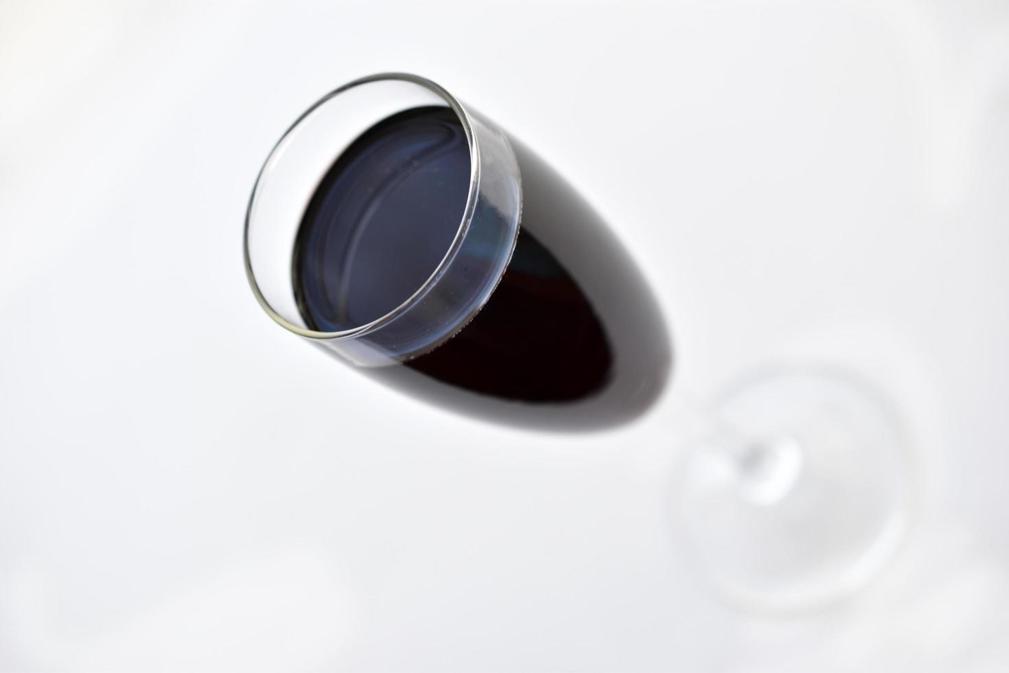 petit verre de vin rouge sur fond blanc avec des ombres photo