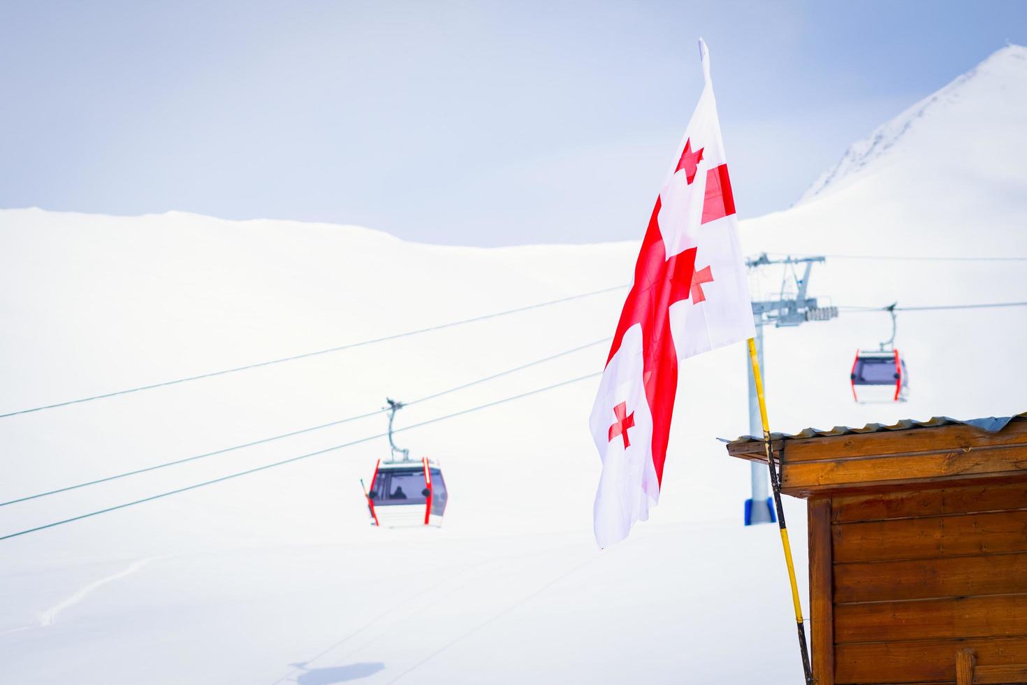gudauri, georgia 2020 - drapeau géorgien avec panorama de gudauri et remontées mécaniques de la cabine de ski photo