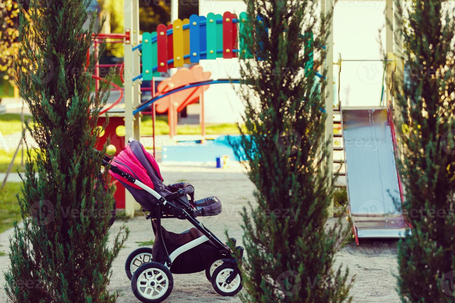 bébé poussette contre Extérieur terrain de jeux avec vert herbe photo