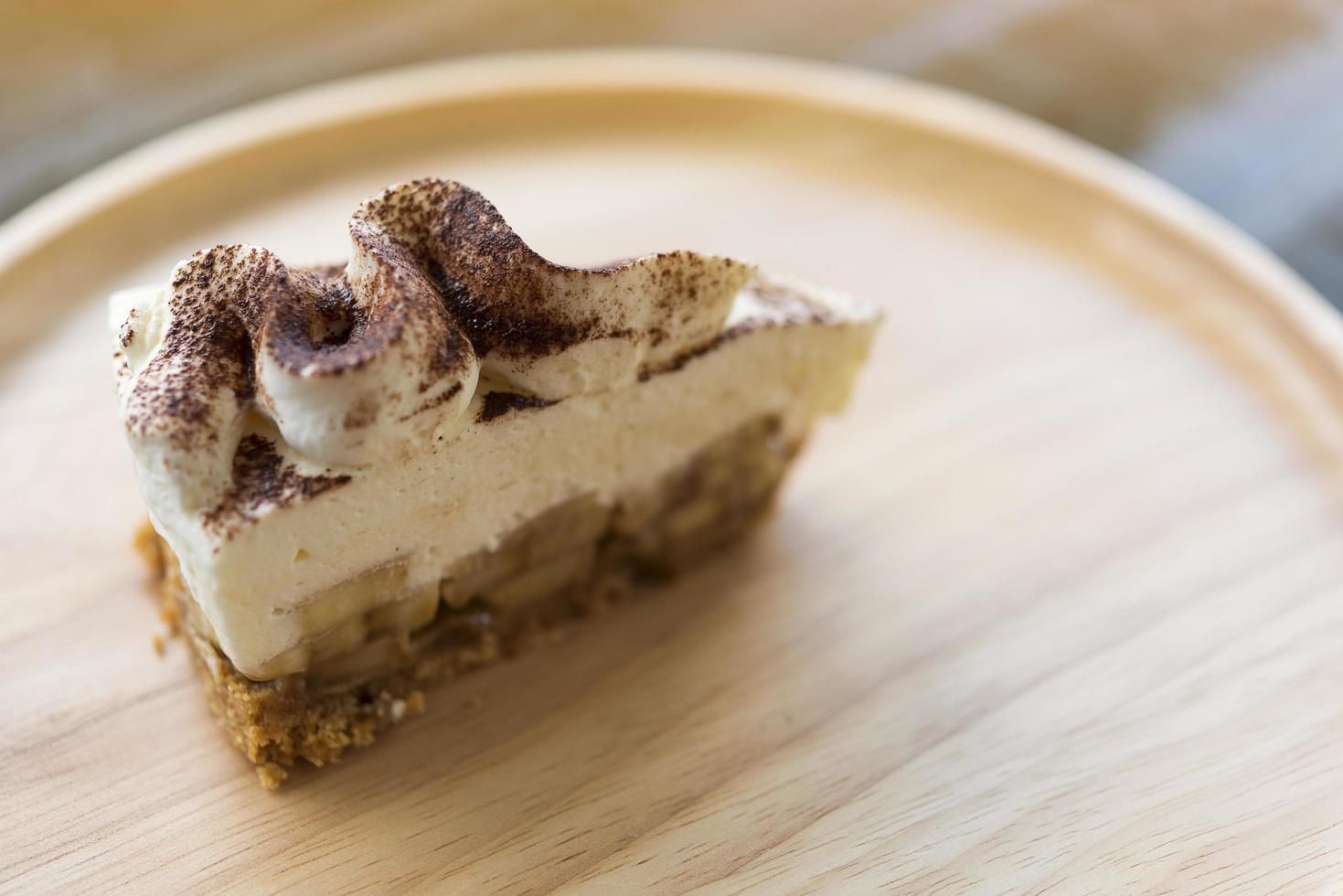 Tarte banoffee avec du chocolat en poudre sur une plaque en bois photo