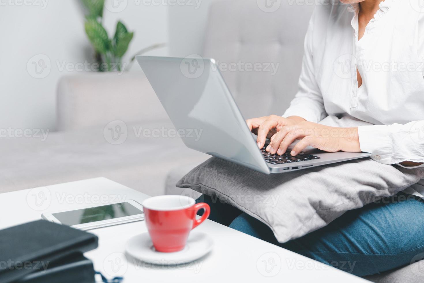 social médias journée concept. femelle pigiste départ travail journée de bonne heure dans Matin en buvant café dans vivant pièce pour site Internet avec en utilisant moderne portable ordinateur. femme d'affaires travail dans Accueil bureau. photo