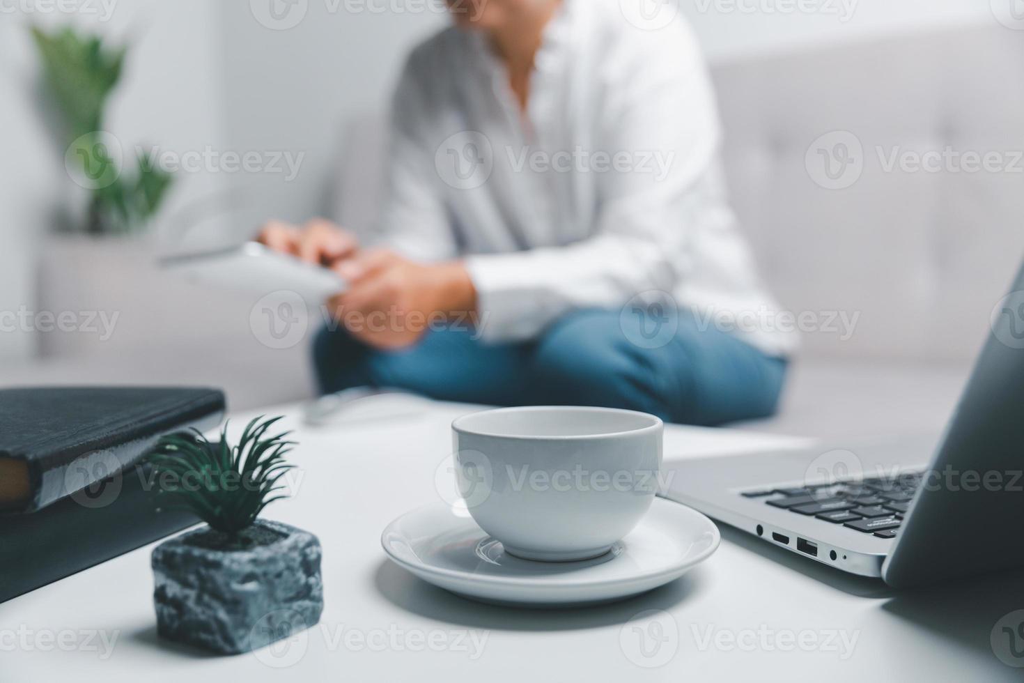 social médias journée concept. femelle pigiste départ travail journée de bonne heure dans vivant pièce pour site Internet avec numérique tablette. femme d'affaires travail dans Accueil bureau. femme communicant avec en ligne technologie. photo