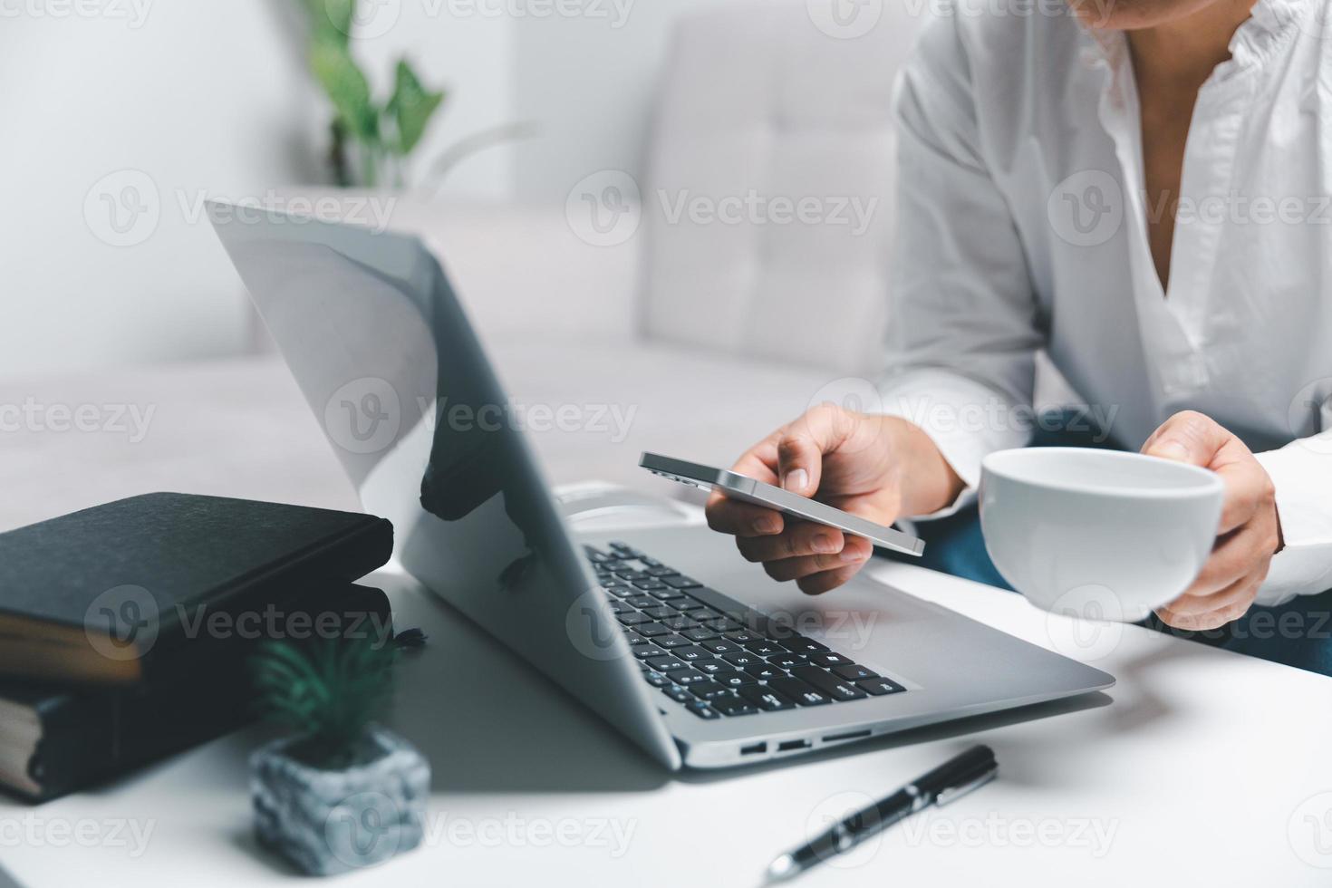 social médias journée concept. femelle pigiste départ travail journée de bonne heure dans vivant pièce pour site Internet avec téléphone intelligent. femme d'affaires travail dans Accueil bureau. femme communicant avec en ligne technologie. photo