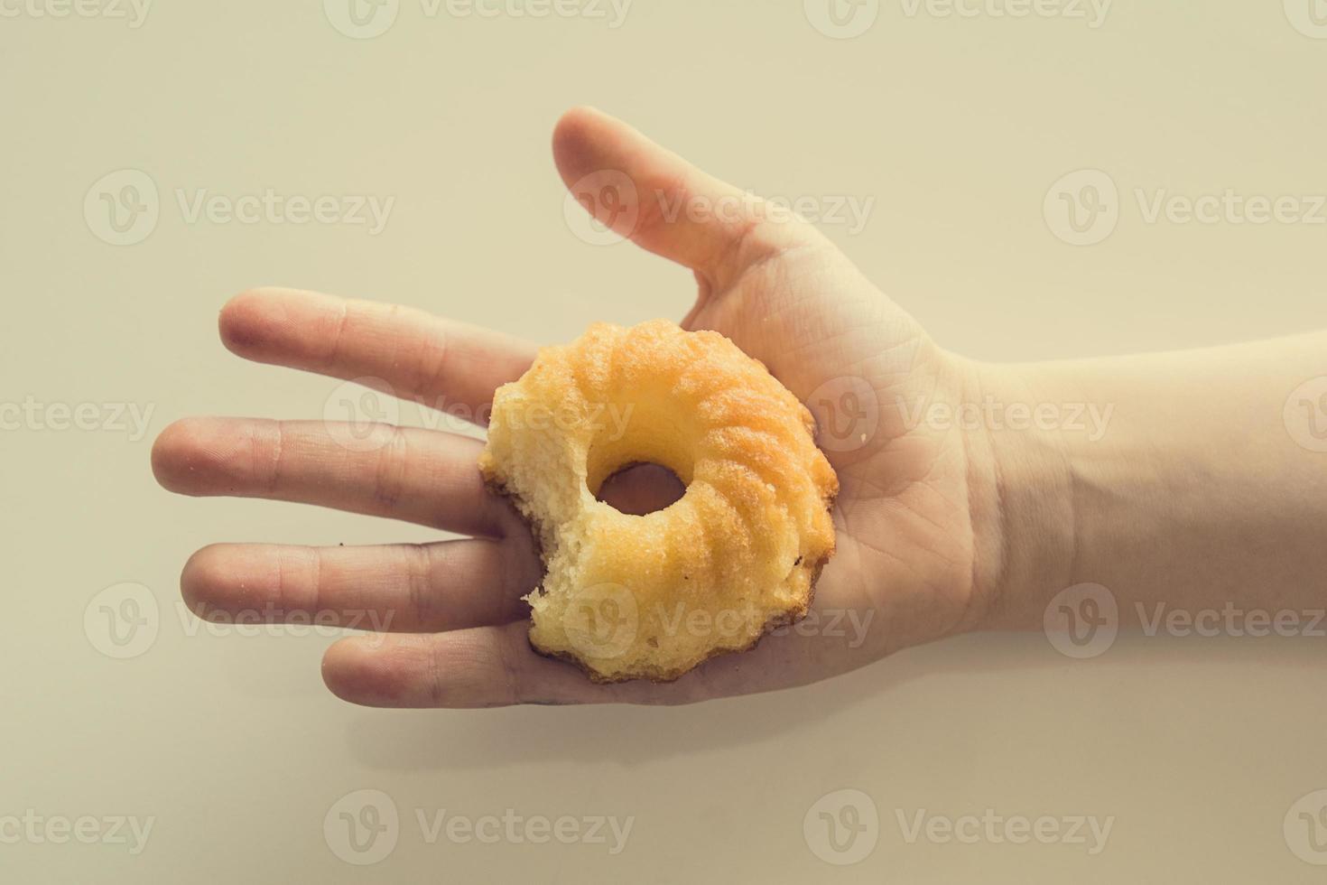 savoureux peu Pâques petit gâteau sur une enfant main sur une lumière Contexte photo