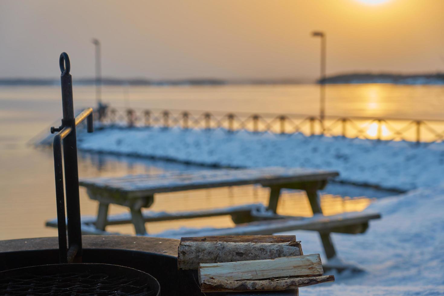 table de pique-nique au coucher du soleil dans la neige photo