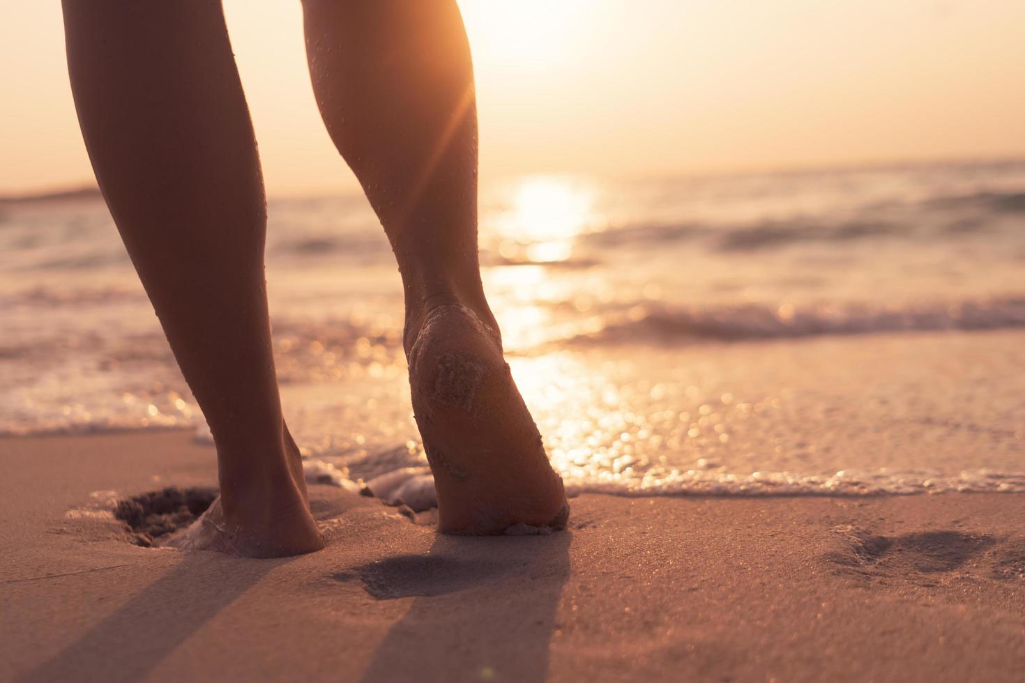 Pieds marchant lentement, vie et détente sur une plage tropicale de sable avec un fond de ciel bleu photo