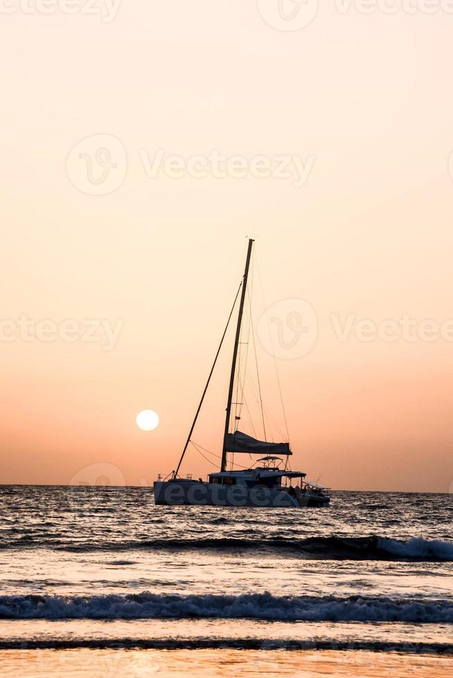 voile yacht à le coucher du soleil photo