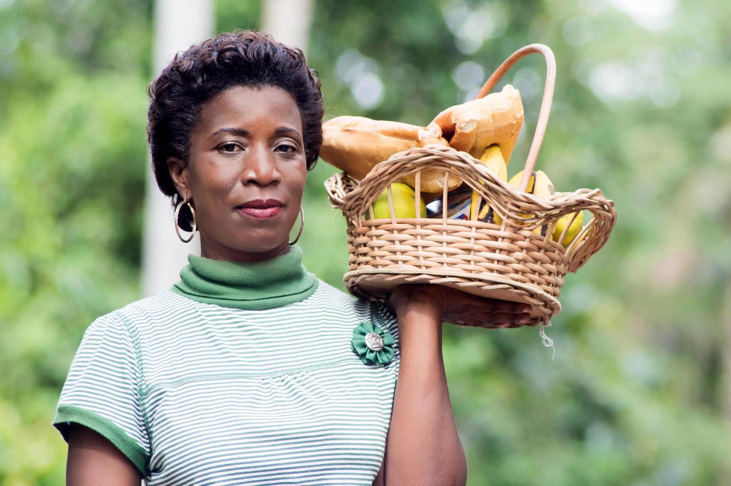 jeune femme tenant un panier de fruits à la main et aller pique-niquer photo