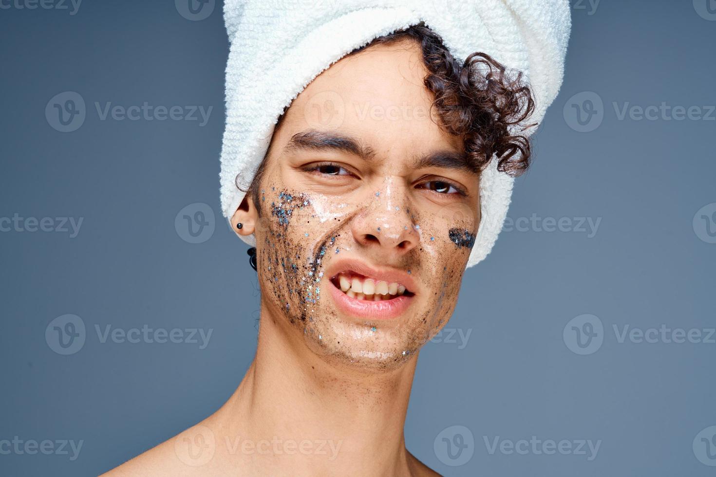 gars avec une serviette sur le sien tête produits de beauté peau se soucier fermer photo