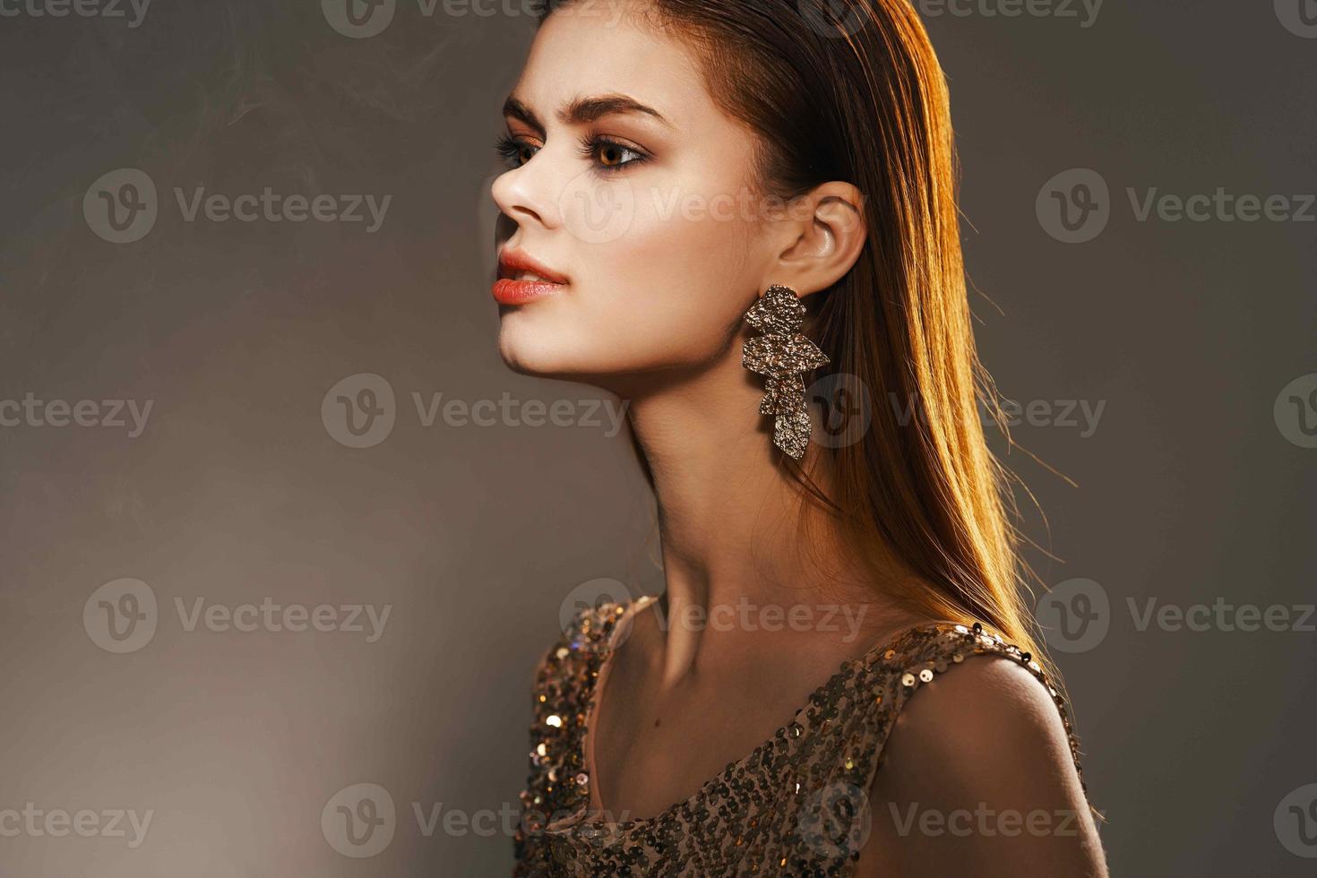 de bonne humeur femme dans une d'or robe bijoux des boucles d'oreilles mode charme photo