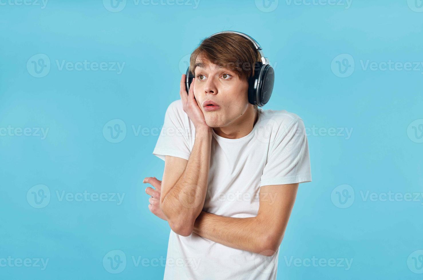 émotif gars dans blanc T-shirt portant écouteurs la musique mode photo