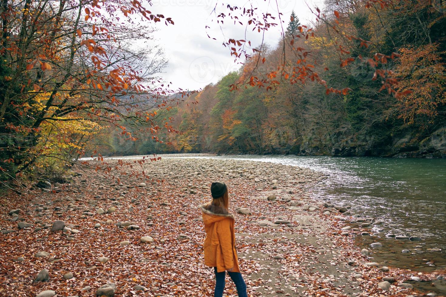 femme dans une Jaune veste près le rivière montagnes la nature marcher photo