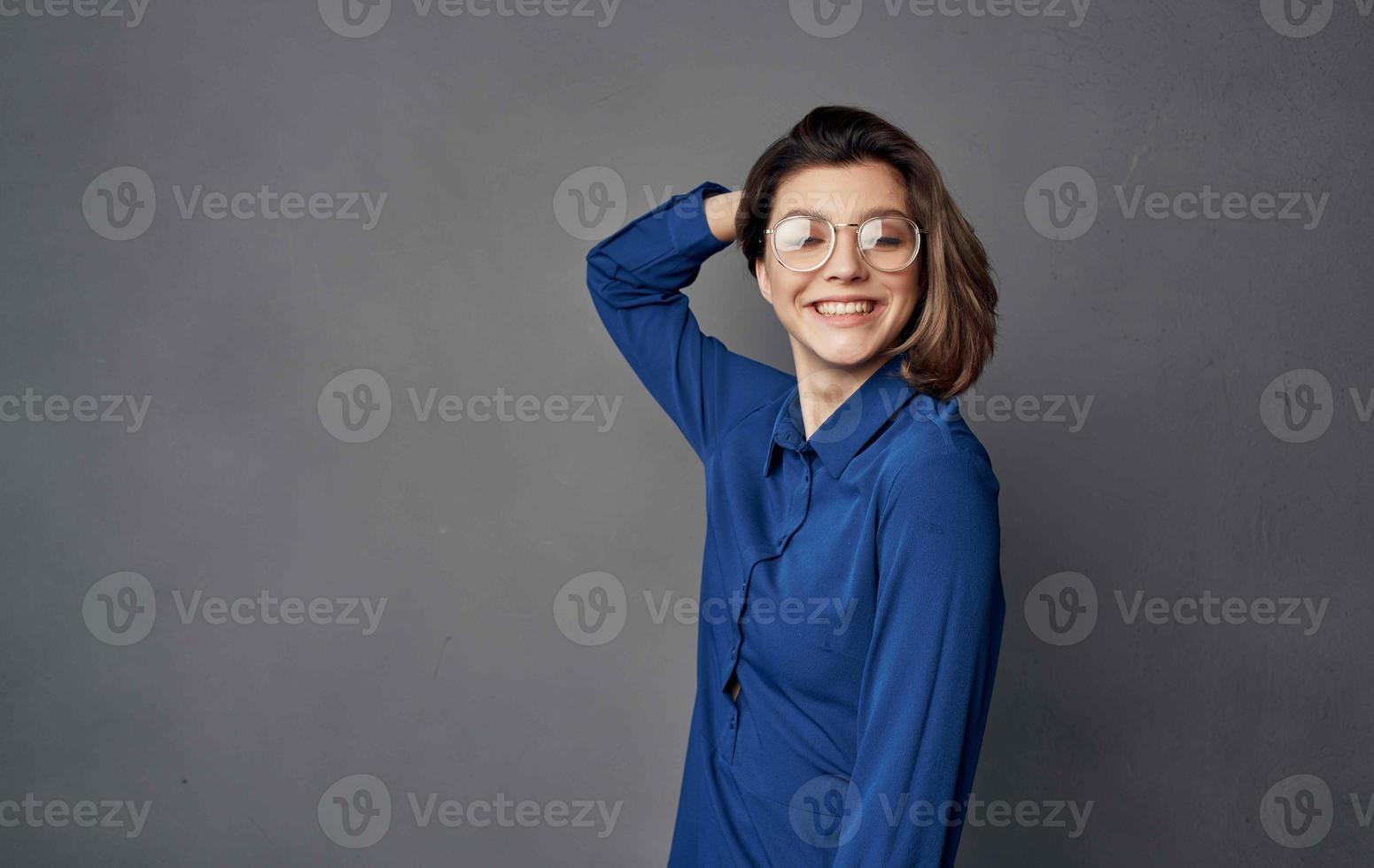 femme dans bleu chemise portant des lunettes élégant style isolé Contexte photo