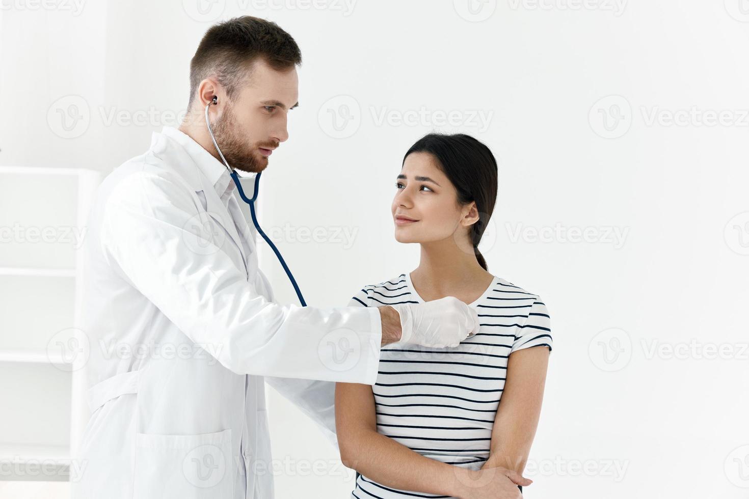 médecin dans une blanc manteau stéthoscope examen de une patient hôpital photo