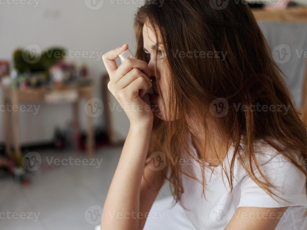 femme séance sur lit avec une thermomètre dans sa bouche fermer photo