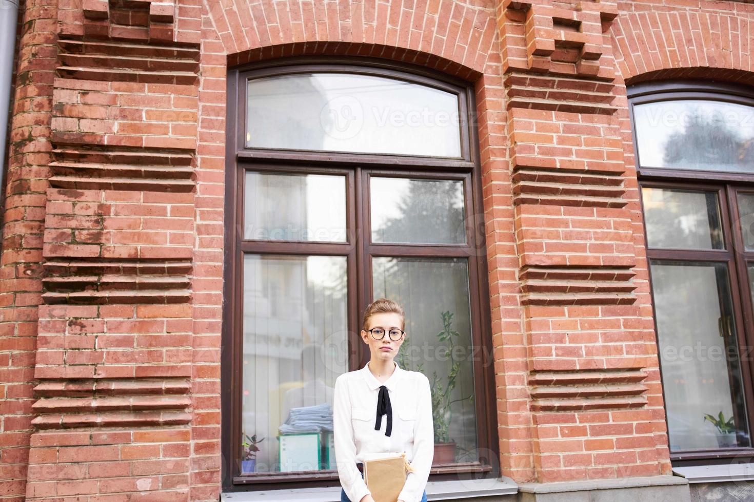 étudiant avec des lunettes en marchant autour le ville avec une livre mode de vie photo