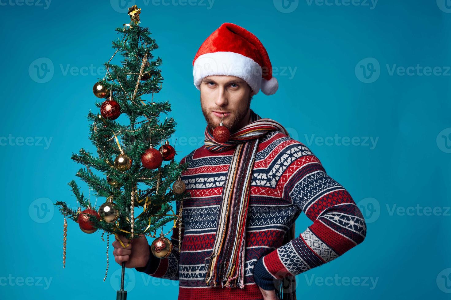 de bonne humeur homme avec une arbre dans le sien mains ornements vacances amusement rouge Contexte photo
