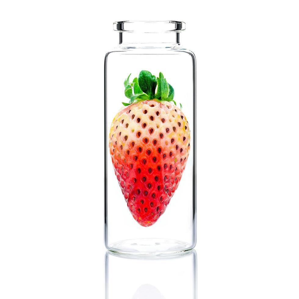 Soins de la peau faits maison avec des fraises fraîches dans une bouteille en verre isolé sur fond blanc photo