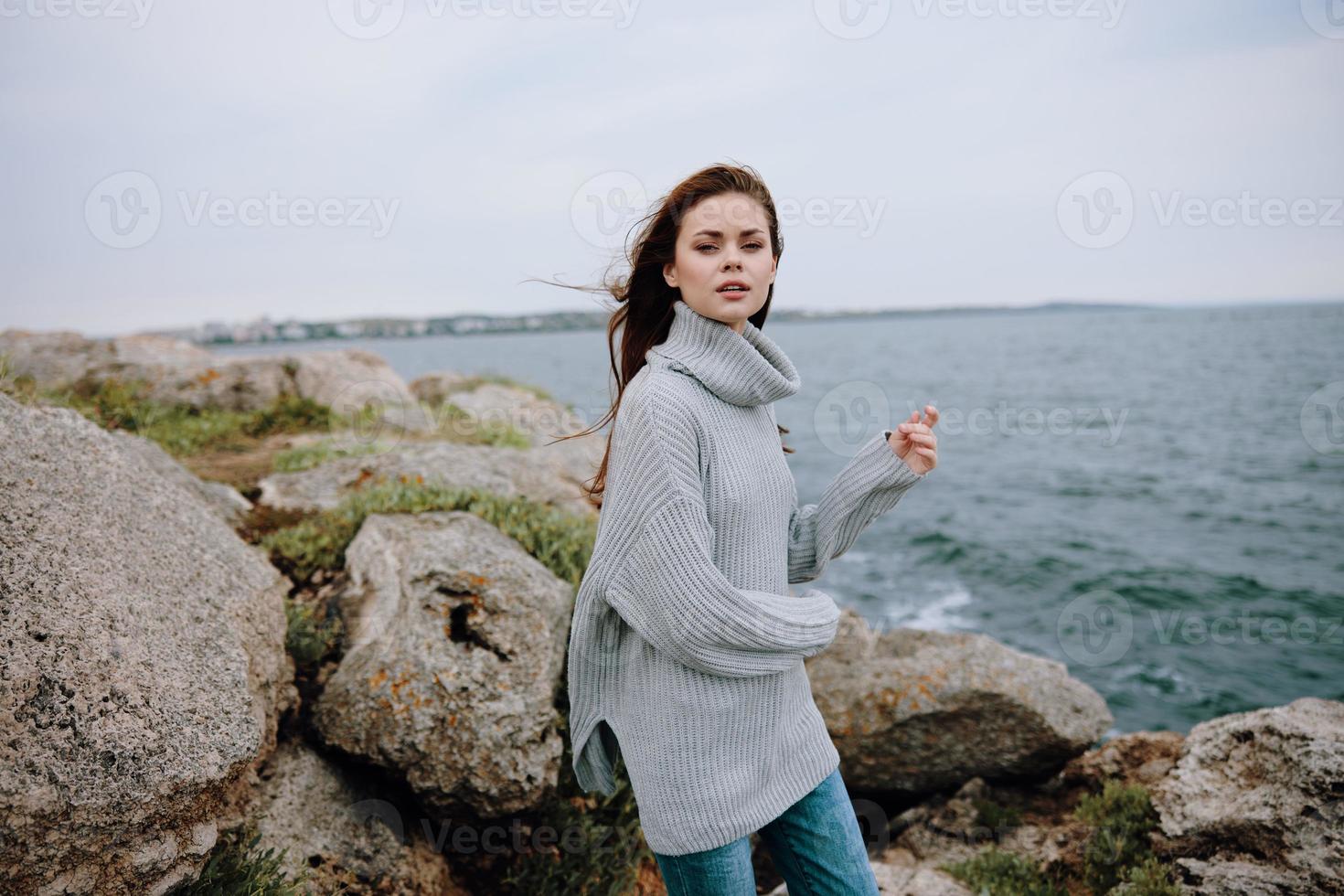 portrait de une femme plage tourisme nuageux temps pierre côte mode de vie photo