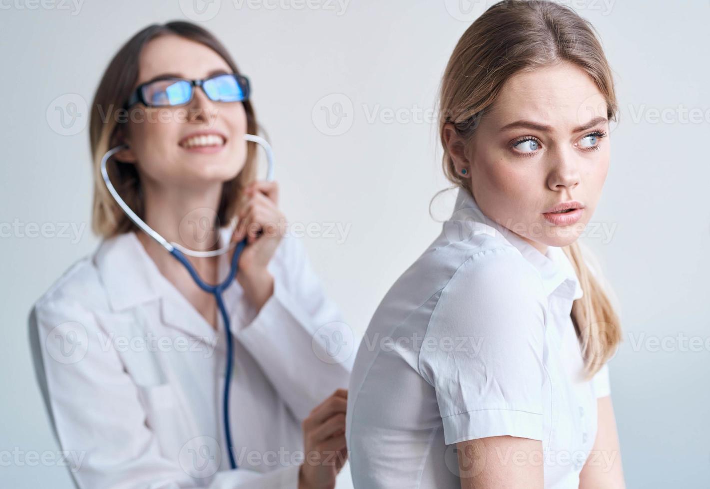 content femme médecin examiner femelle patient dans blanc T-shirt santé modèle photo