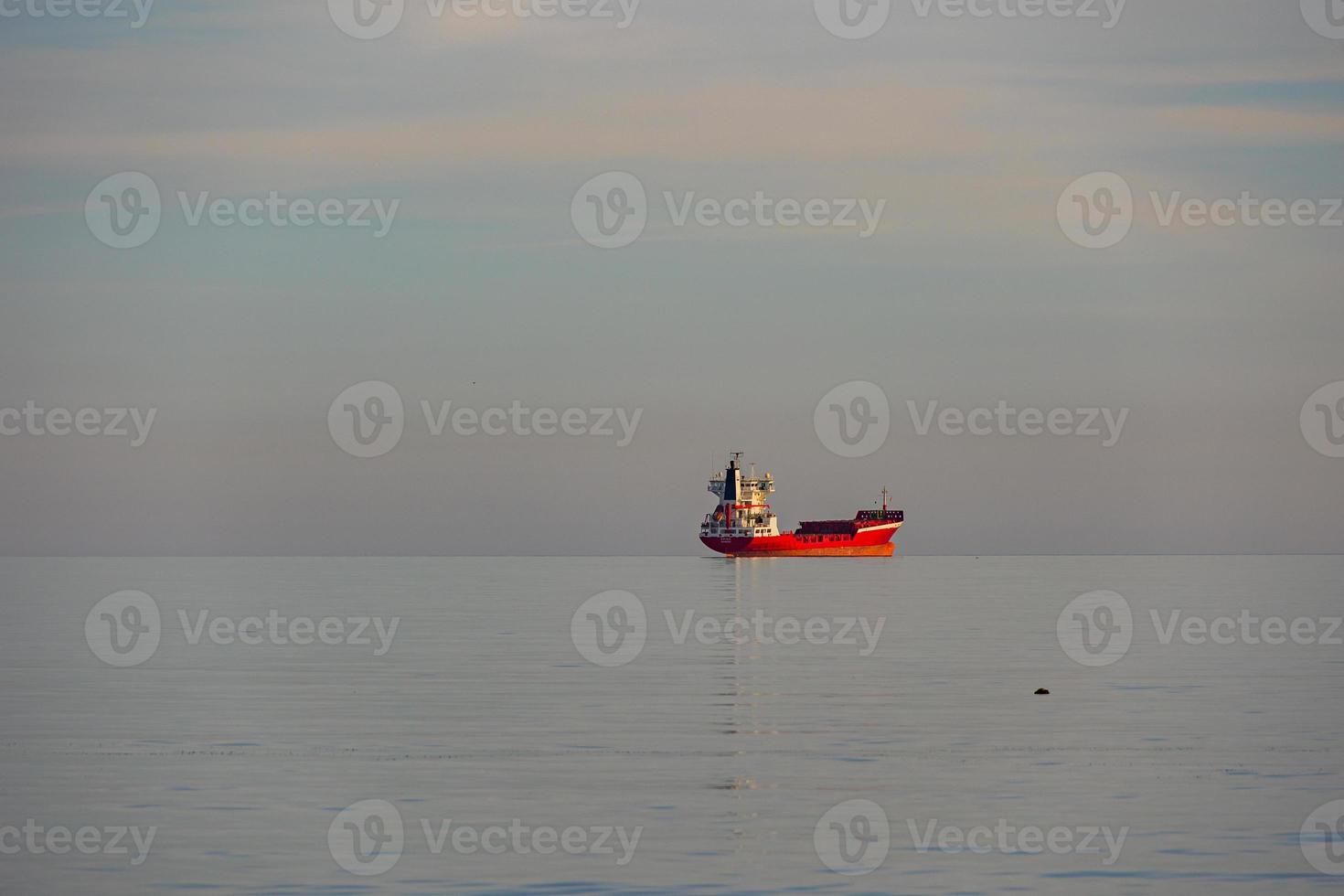 rouge cargaison navire dans le bleu mer calme minimaliste paysage photo