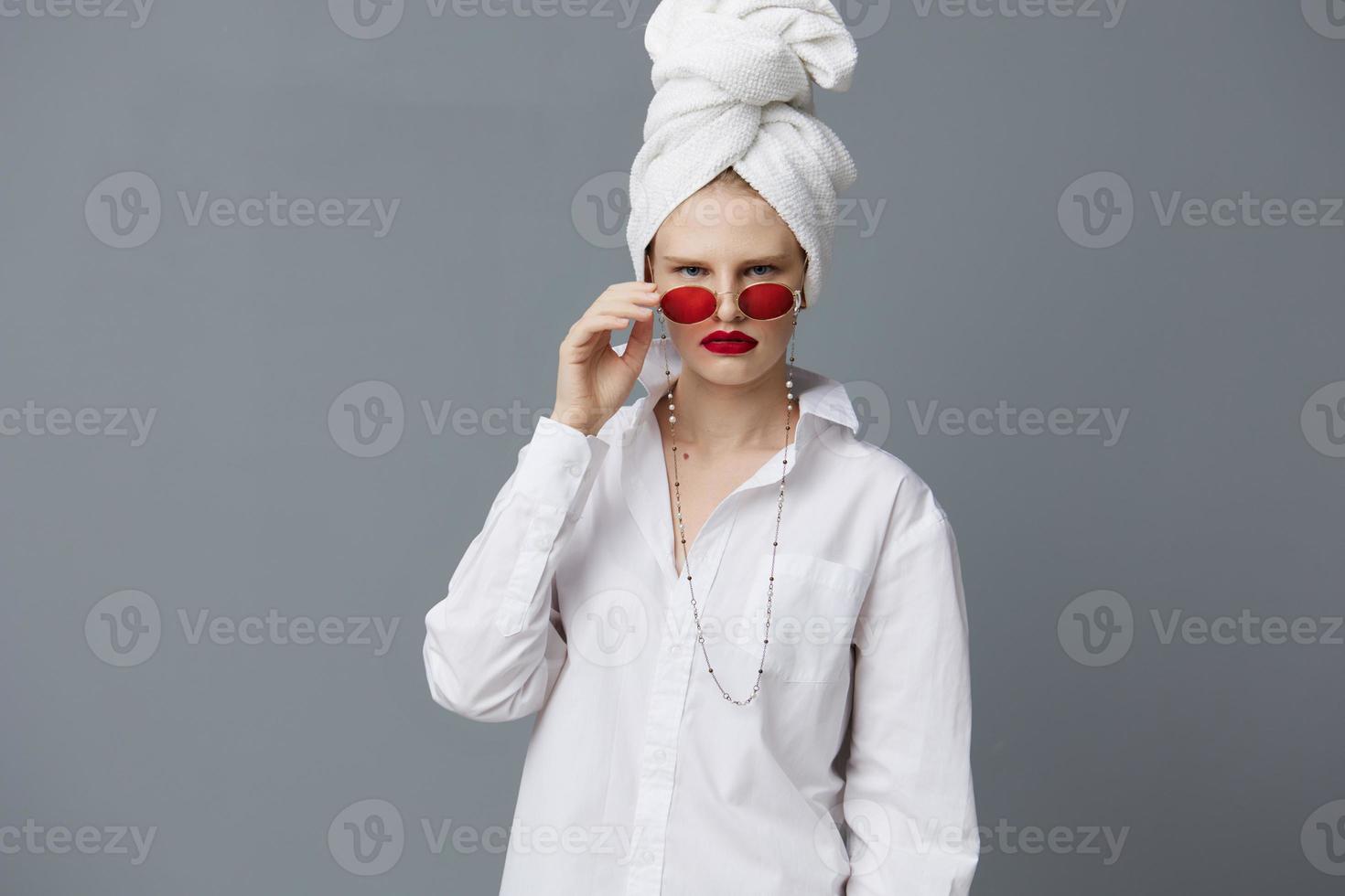 femme avec une serviette sur le sien tête dans une blanc chemise isolé Contexte photo