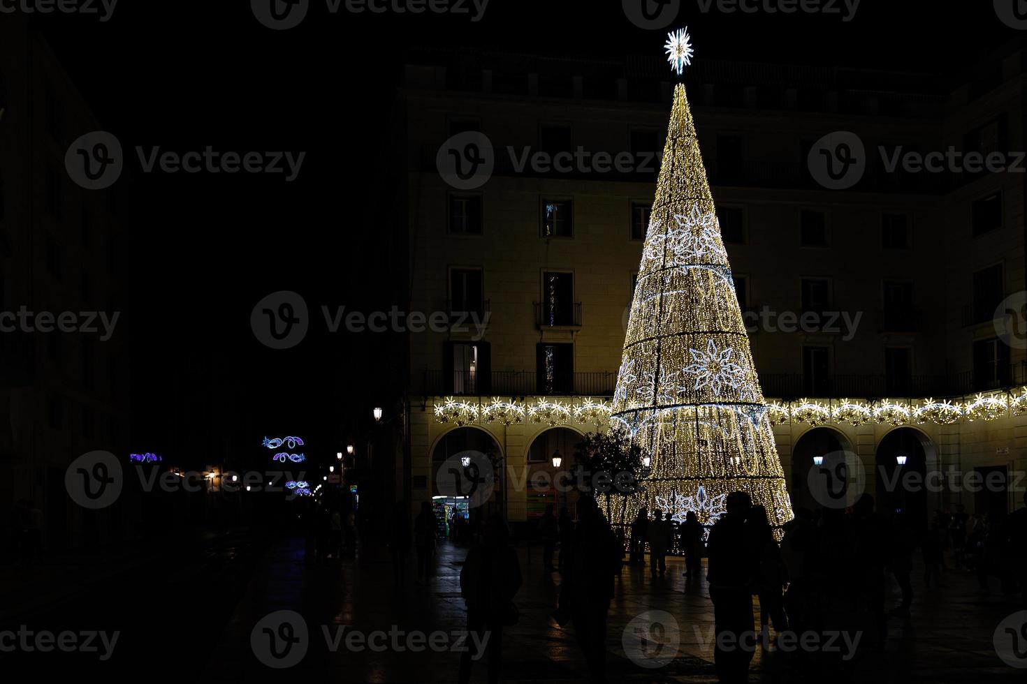 d'or embrasé Noël arbre décoration sur noir Contexte alicante Espagne dans de face de le ville salle photo