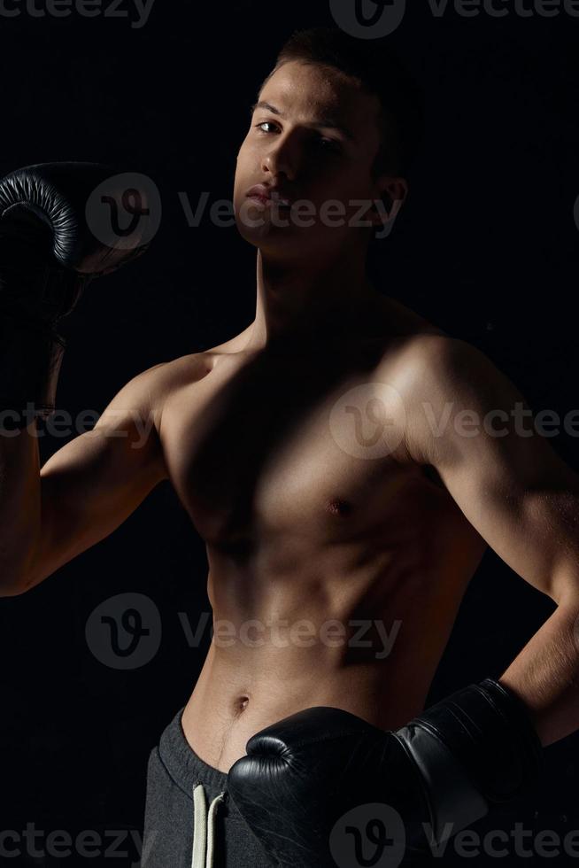 athlète dans boxe gants sur noir Contexte portrait tondu vue modèle photo