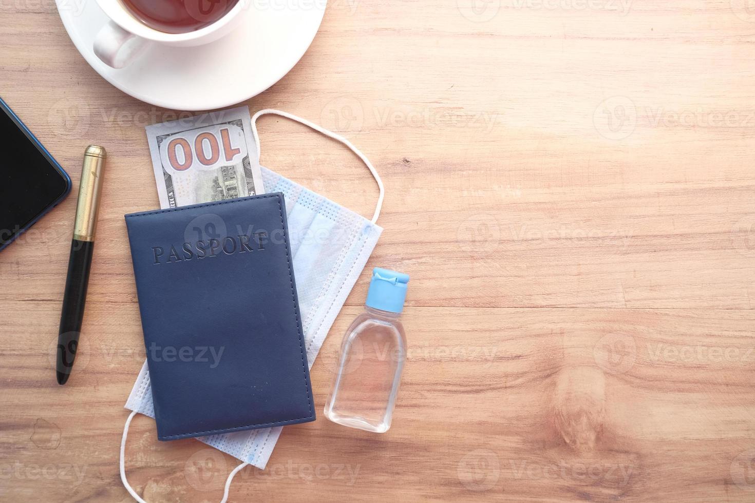 passeport, argent et désinfectant pour les mains sur la table photo