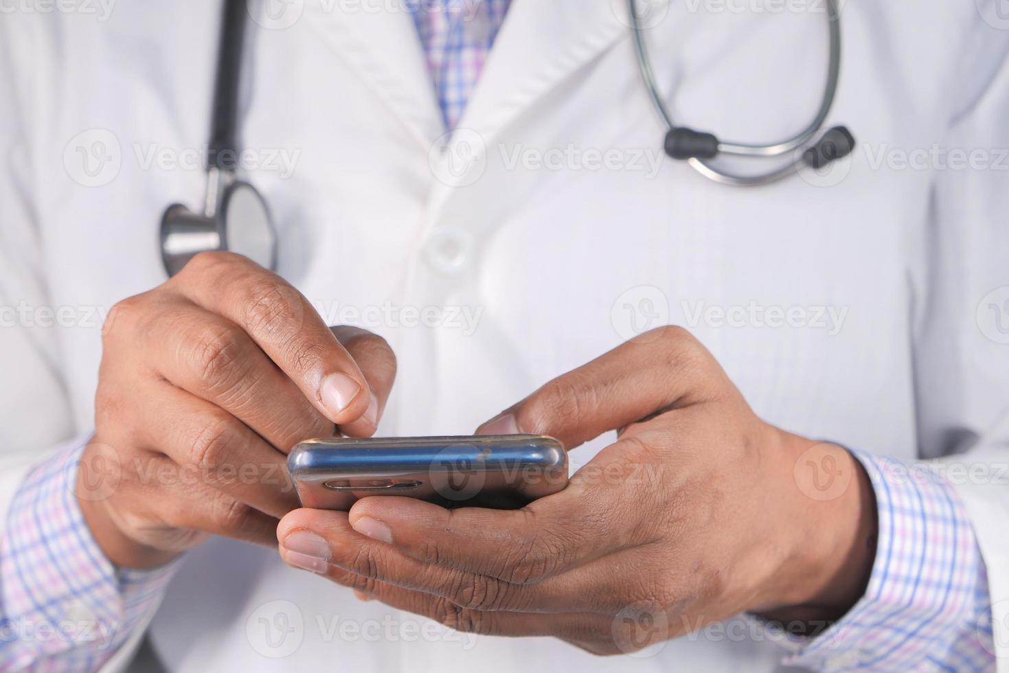 médecin en blouse blanche à l'aide d'un smartphone photo