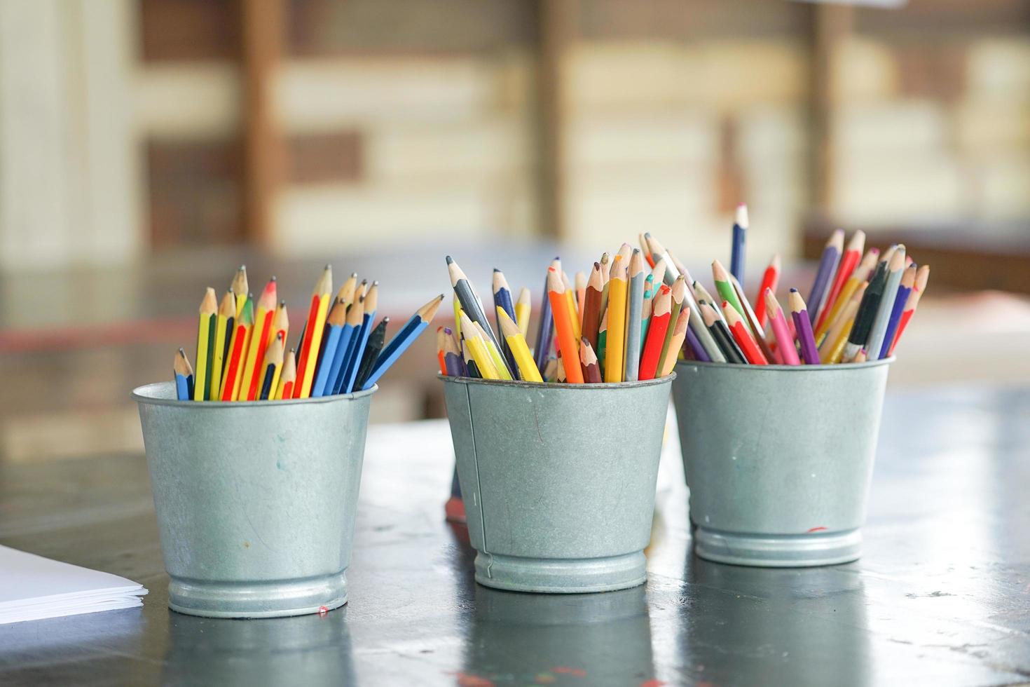 Gros plan des crayons de couleur émoussés dans des seaux métalliques photo