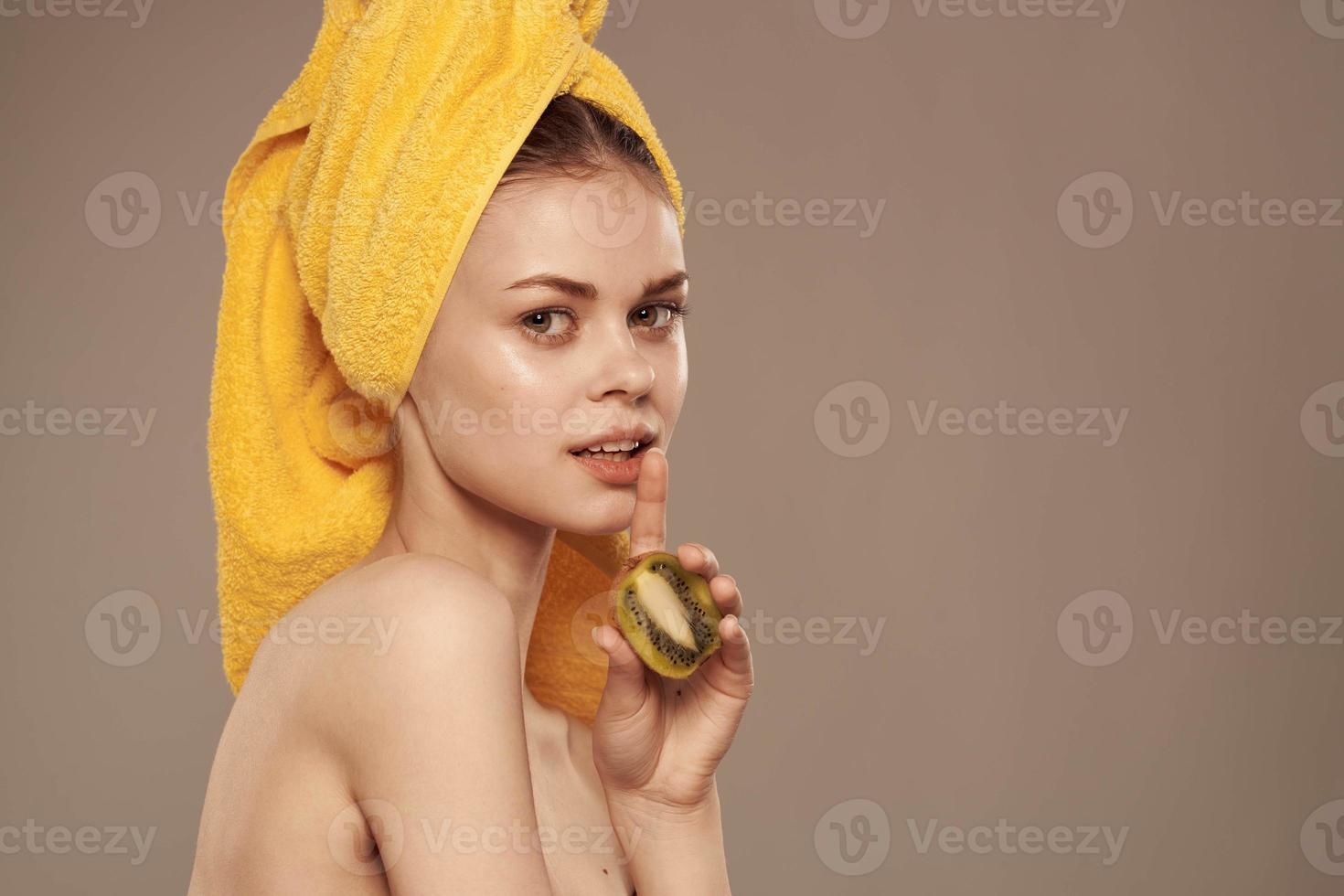 magnifique femme kiwi fruit en portant vitamines santé nettoyer peau beige Contexte photo