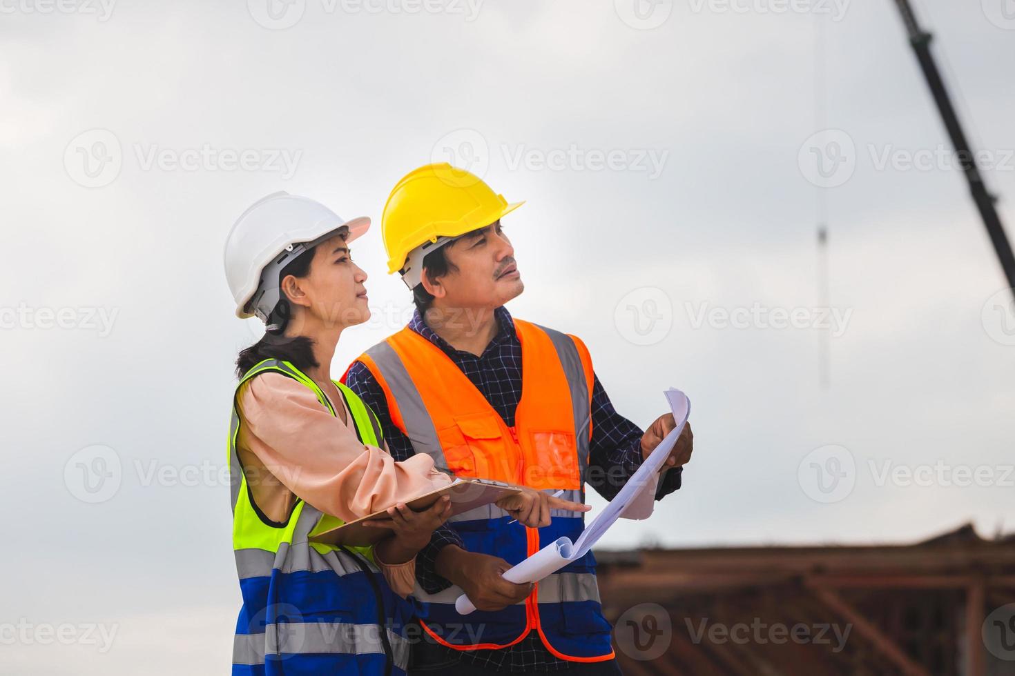 ingénieur et contremaître ouvrier vérification projet à bâtiment construction site photo