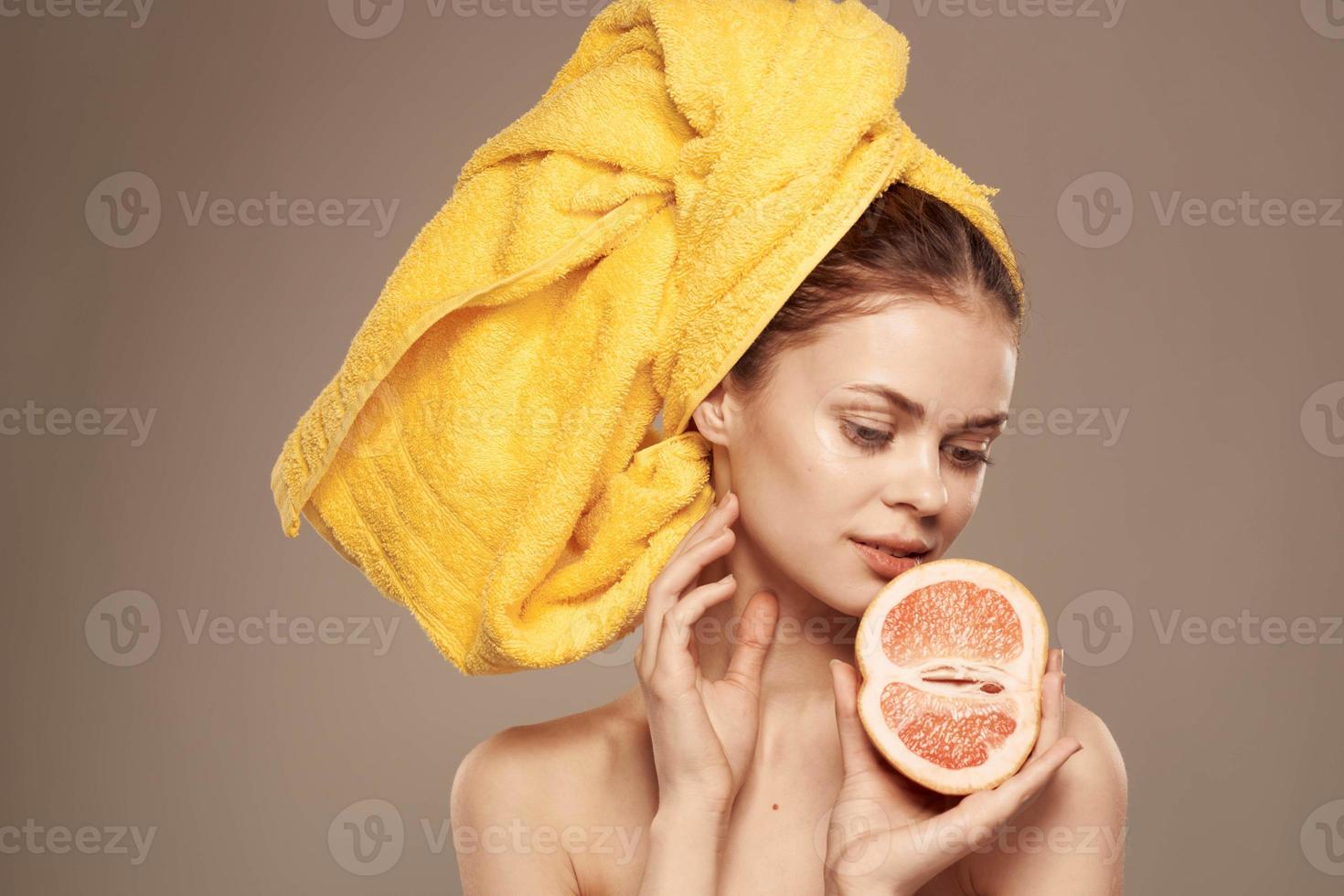 femme avec pamplemousse dans mains nu épaules et peau se soucier vitamines photo